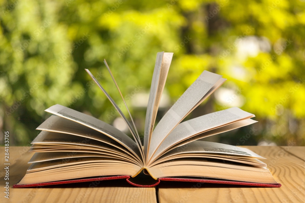 Open book on old wooden table.