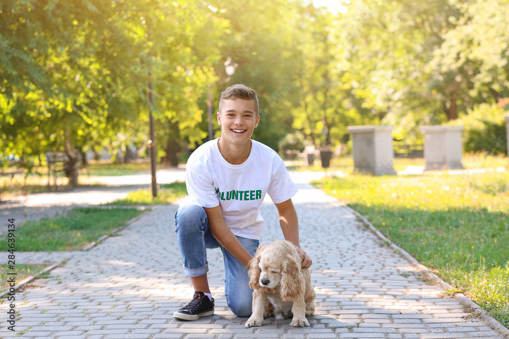 Teenage volunteer with cute dog outdoors