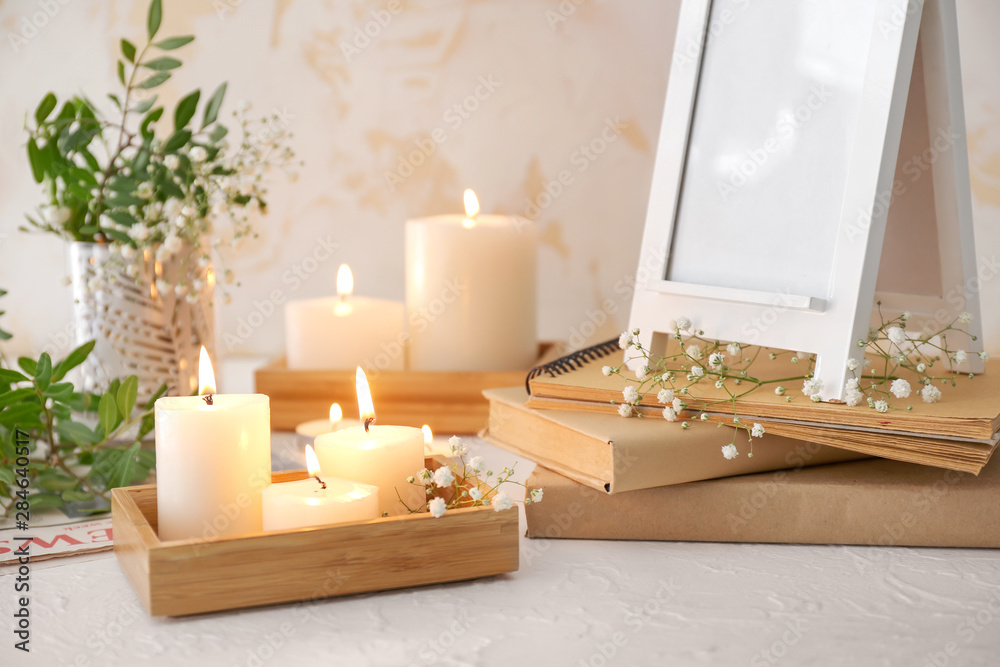 Beautiful burning candles and floral decor on table