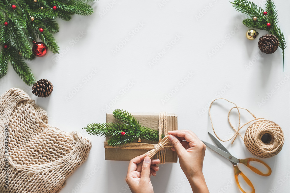 Hand making gift/presents box for christmas concept with decorations over white background and copy 