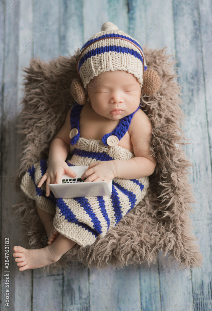 Adorable newborn baby sleeping in cozy room. Cute happy infant baby portrait with sleepy face in bed