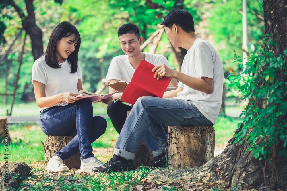 在大学或学校公园的小组项目中学习的年轻学生团队。快乐学习