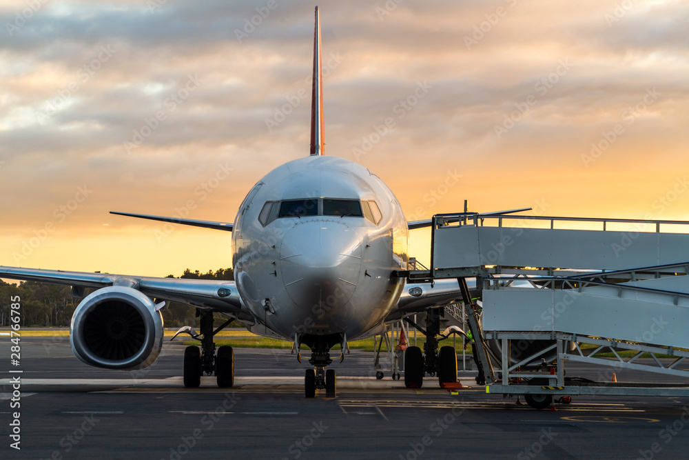 Sunset view of airplane on airport runway under dramatic sky in Hobart,Tasmania, Australia. Aviation