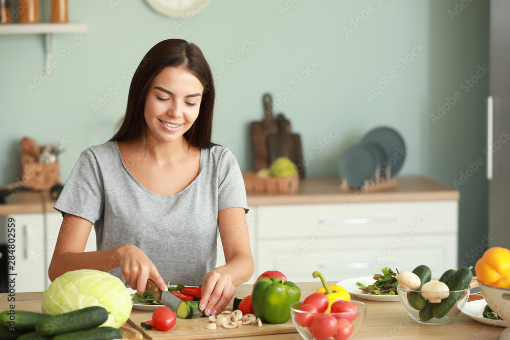 美丽的年轻女人在厨房做饭