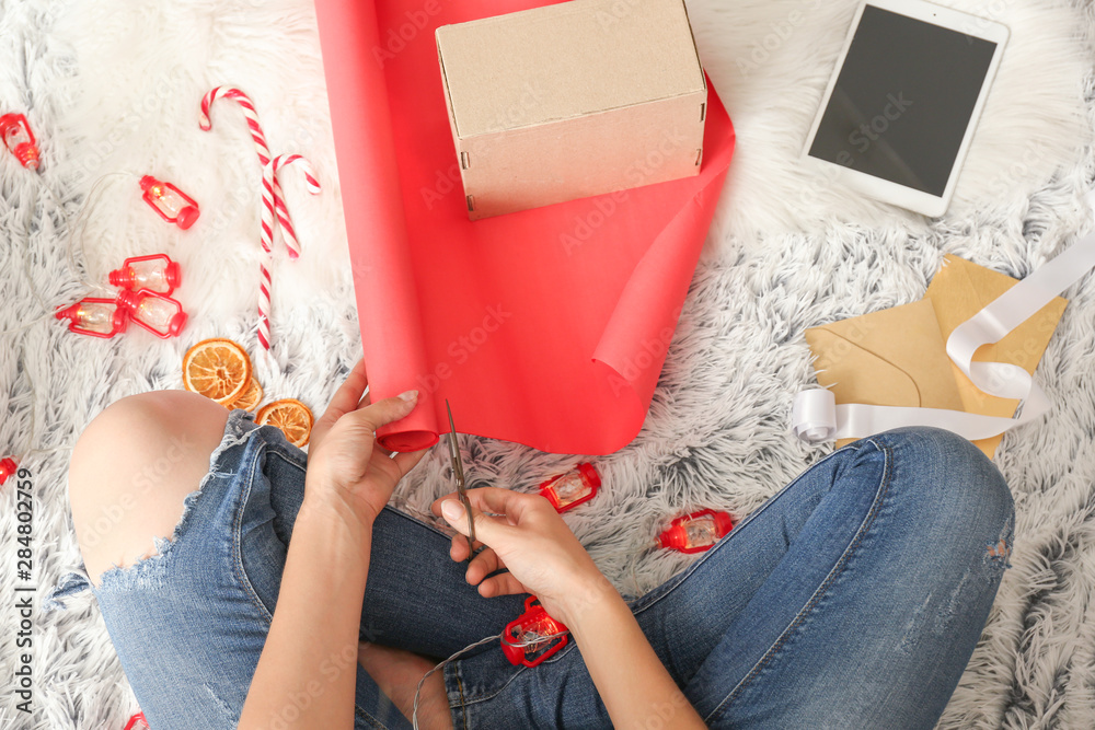 Woman making Christmas gift on floor