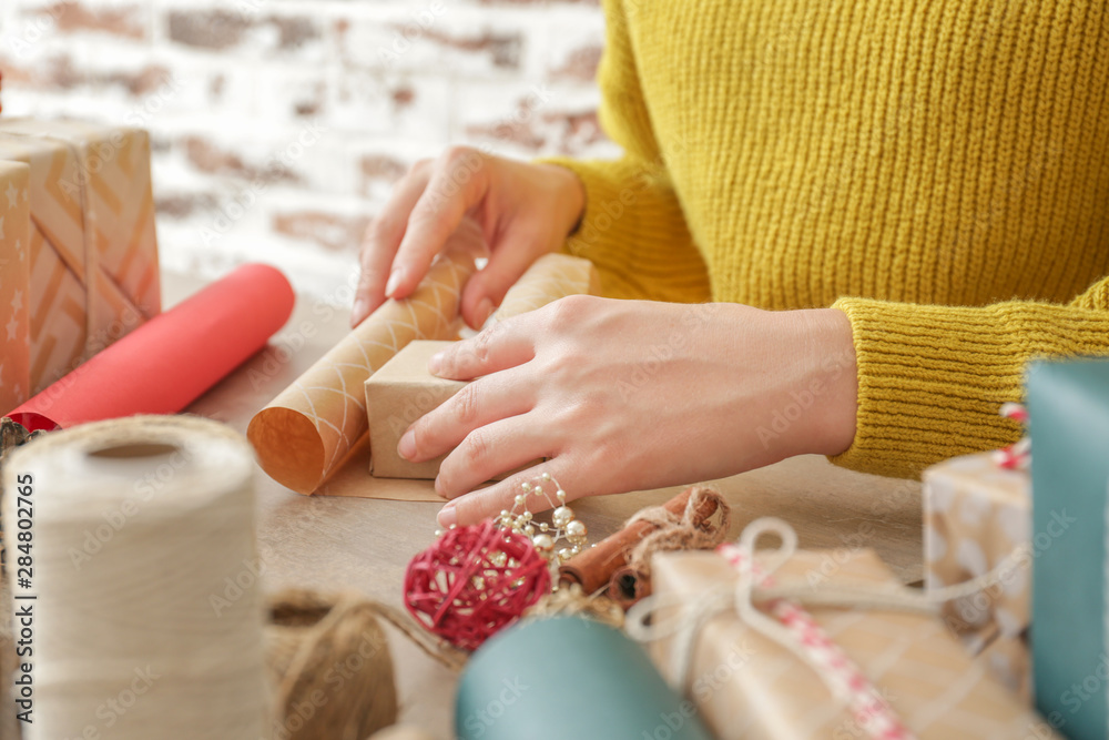 Woman making Christmas gift at table, closeup