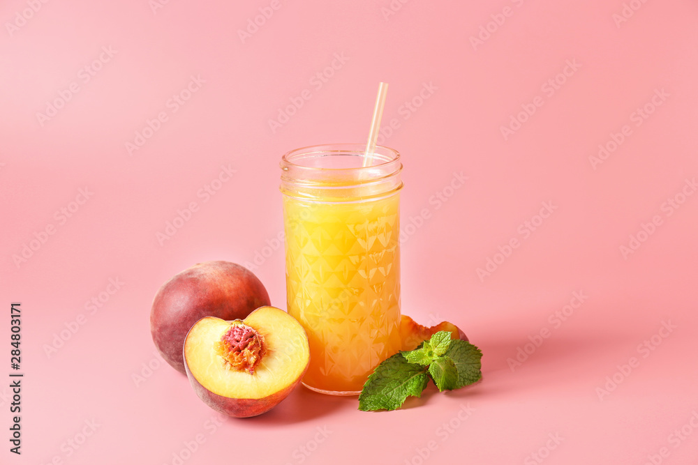 Jar of tasty peach juice on color background