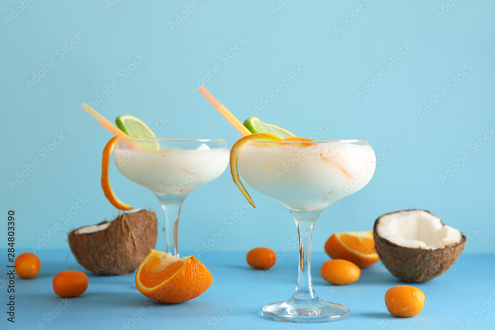 Glasses of tasty Pina Colada cocktail and fruits on color background