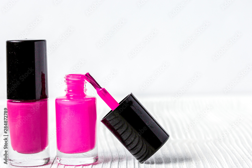 open bottles of nail polish on wooden background close up