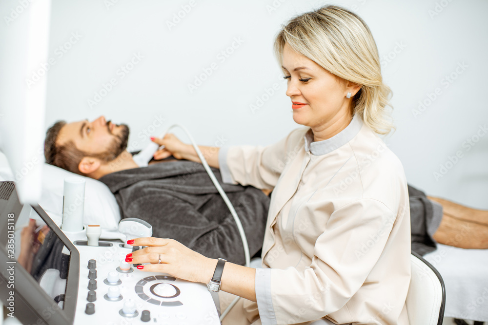 Doctor examining mens thyroid with ultrasound