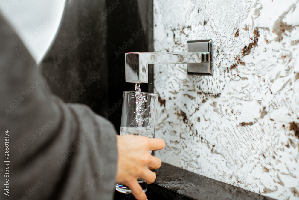 Pouring mineral thermal water into the drinking glass