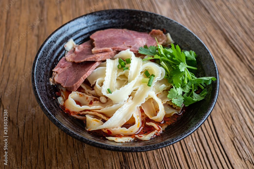 A bowl of nutritious and delicious beef noodles on a wooden table