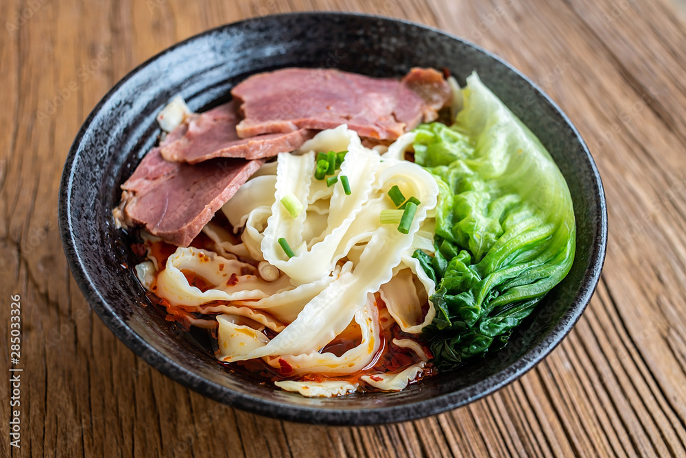 A bowl of nutritious and delicious beef noodles on a wooden table