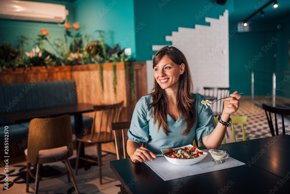 Smiling woman enjoying healthy lunch, portrait.