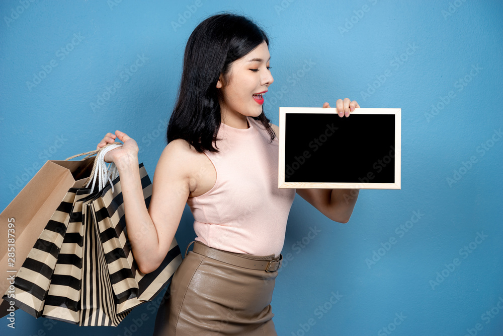 Shopping Woman concept, portrait or isolated an beautiful Asian woman wearing dress, holding shoppin