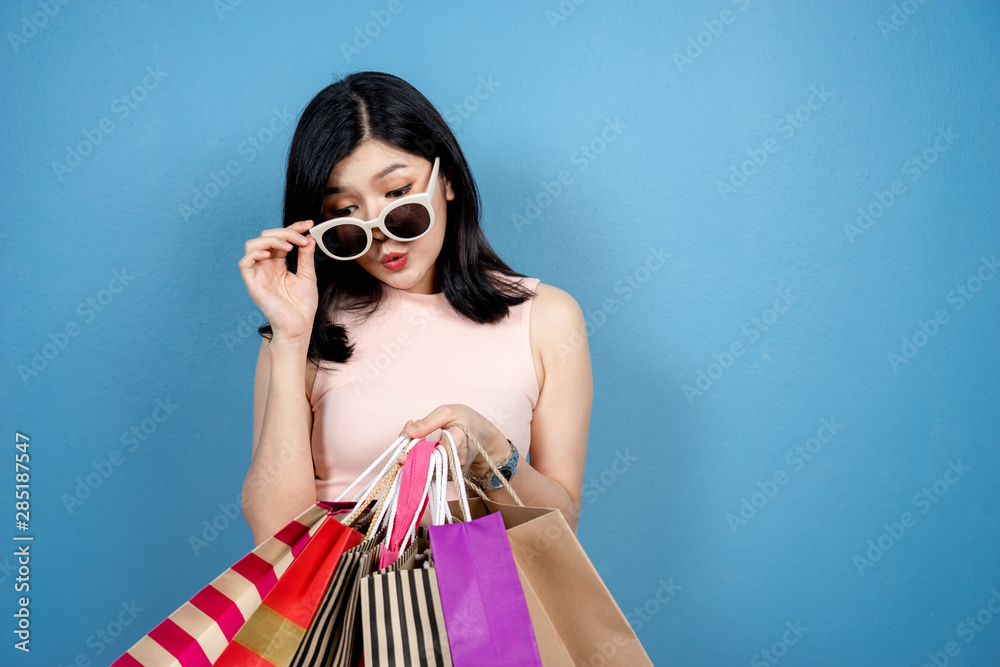 Shopping Woman concept, portrait or isolated an beautiful Asian woman wearing dress, hat and sunglas