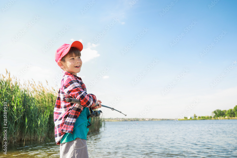 Cute little boy fishing on river