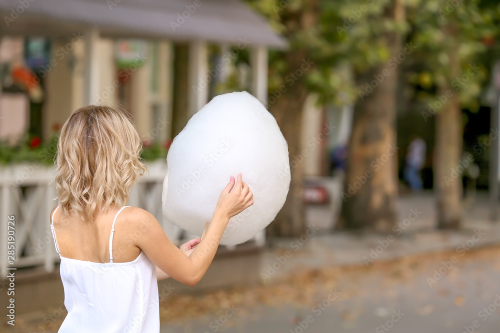 Woman with sweet cotton candy outdoors