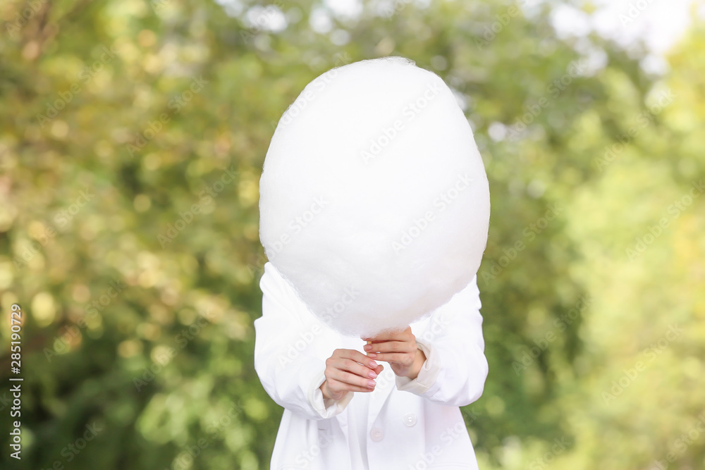 Woman with sweet cotton candy outdoors