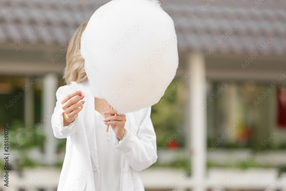 Woman with sweet cotton candy outdoors