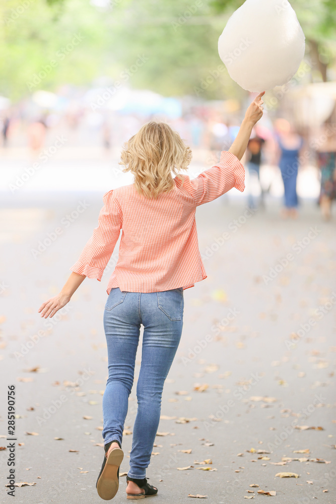 女人在户外拿着甜棉花糖，后视