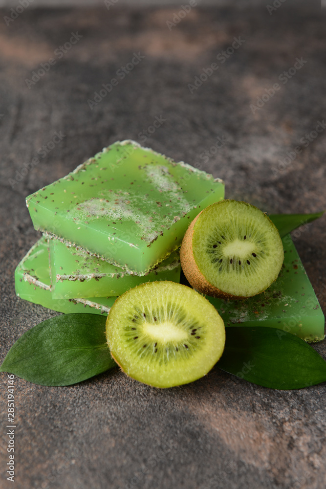 Soap bars with kiwi on grey background