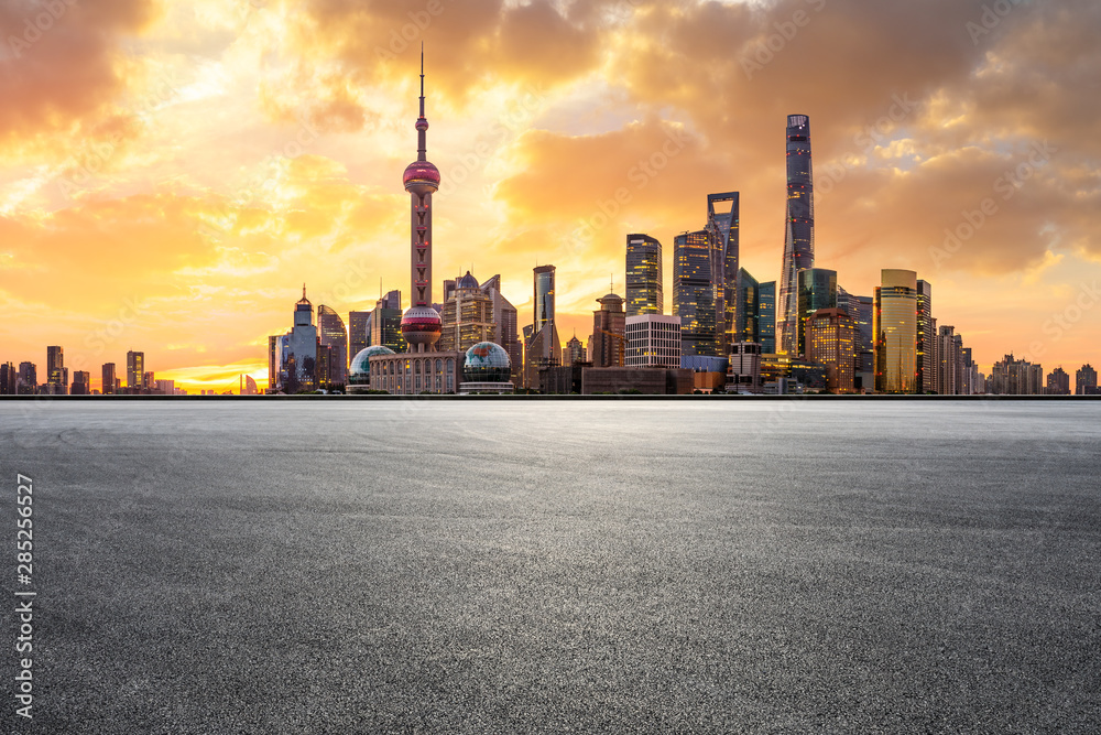 Shanghai skyline and modern buildings with empty race track at sunrise,China.