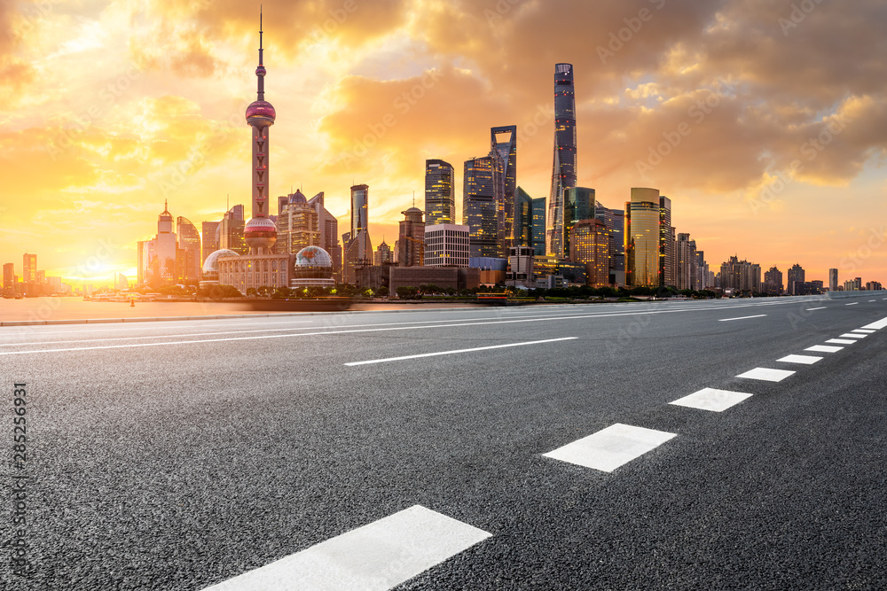 Shanghai skyline and modern buildings with empty asphalt highway at sunrise,China.