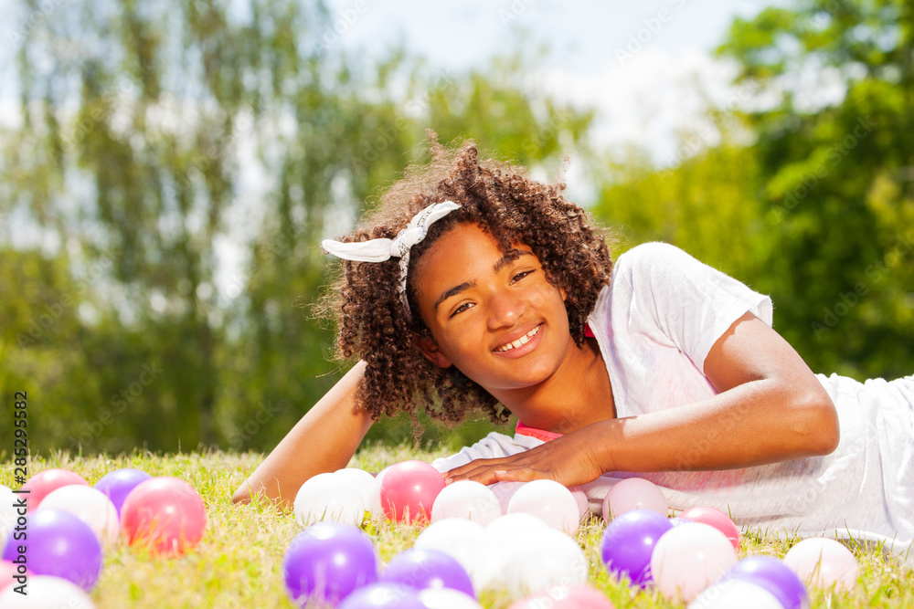 Portrait of a young girl laying in the lawn grass