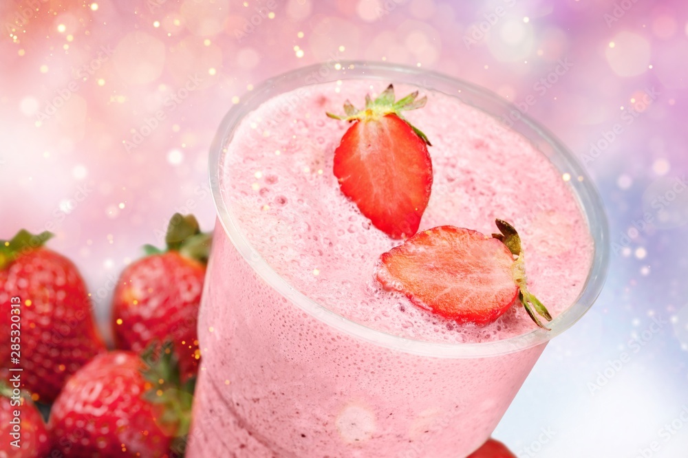 Glass of strawberry smoothie on wooden table