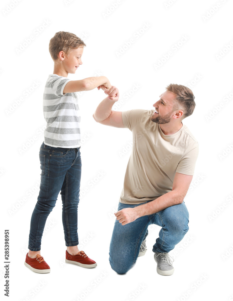 Portrait of happy father and son bumping fists on white background