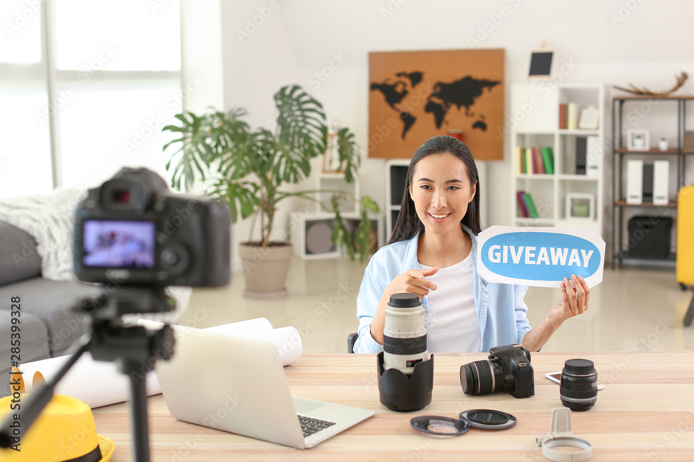 Female Asian blogger announcing giveaway while recording video at home