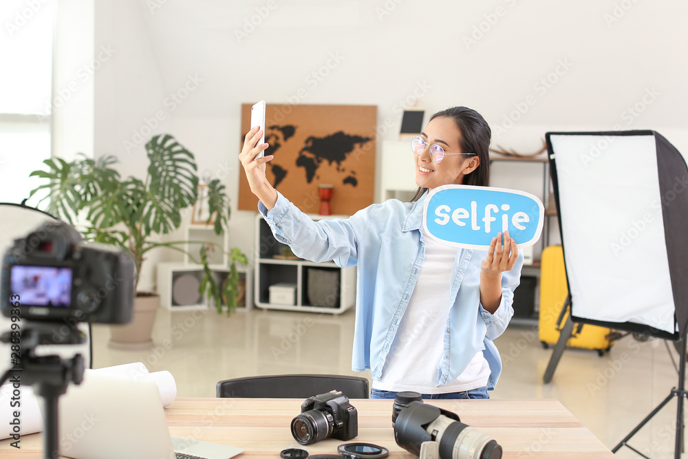 Female Asian blogger taking selfie at home