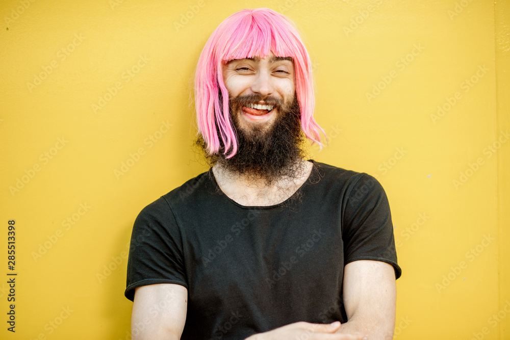 Funny portrait of a stylish playful man with beard and long color hair with expressive emotions on t