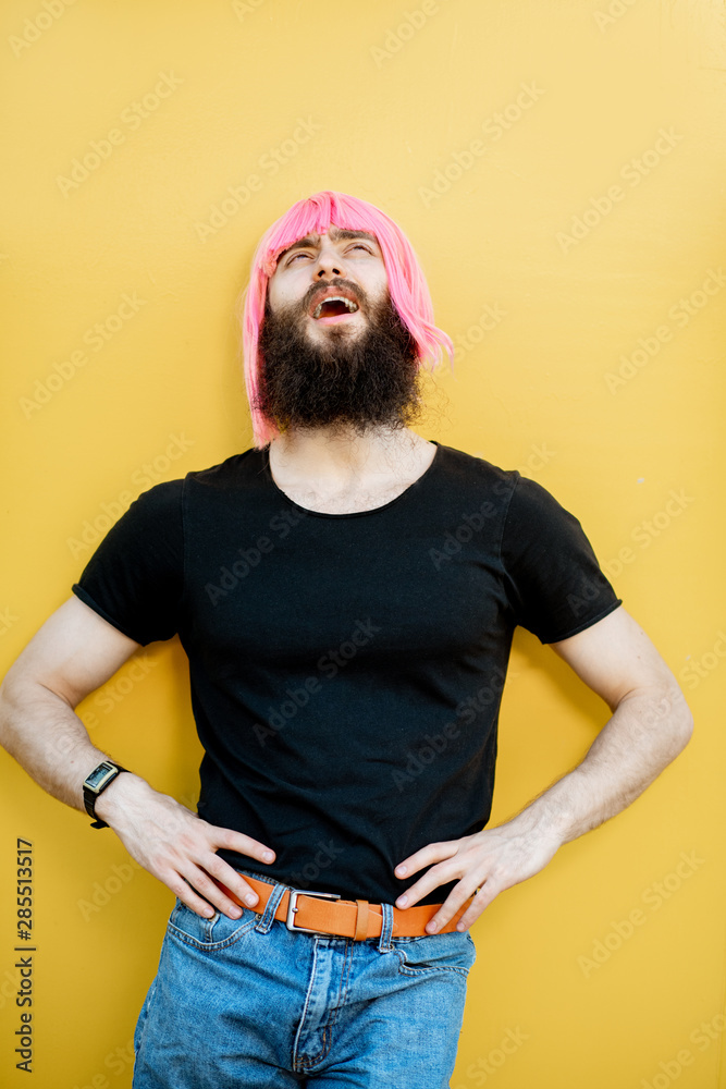 Funny portrait of a stylish playful man with beard and long color hair with expressive emotions on t