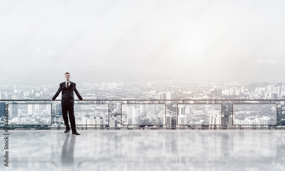 Sunrise above skyscrapers and businessman facing new day