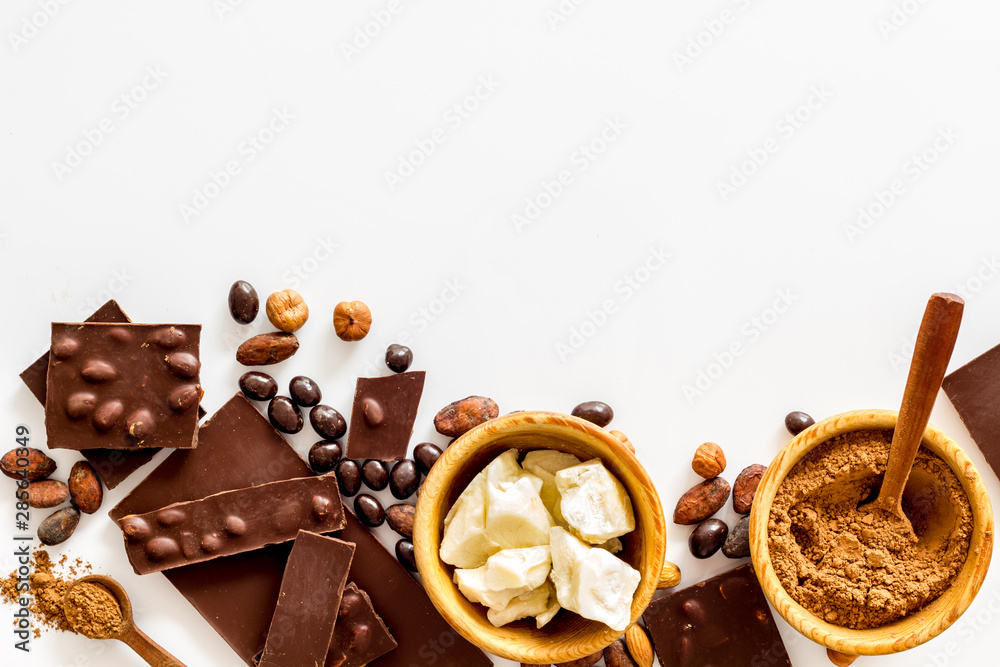 Chocolate bars and nuts on white table background top view mockup