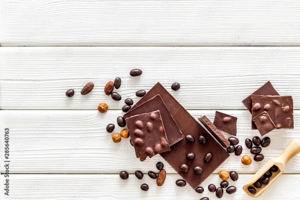 Cook homemade chocolate with bars, nuts, coffee beans on white wooden background top view mock up