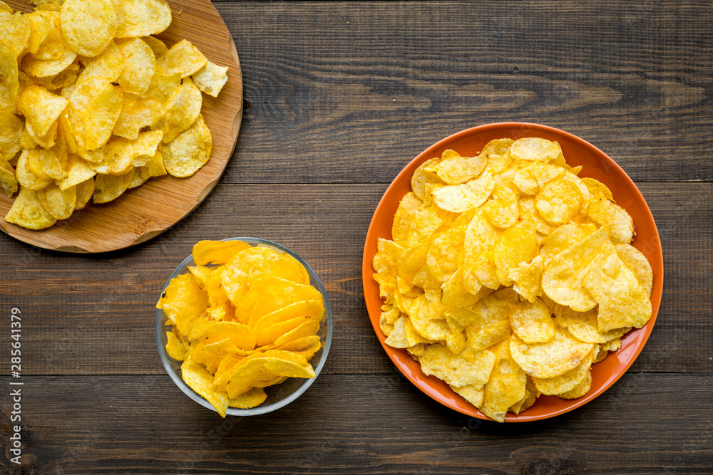 Potato crisps on wooden background top view