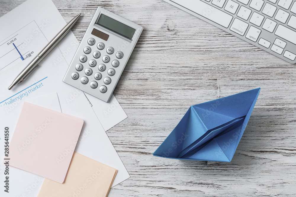 Modern office workspace with blue paper ship