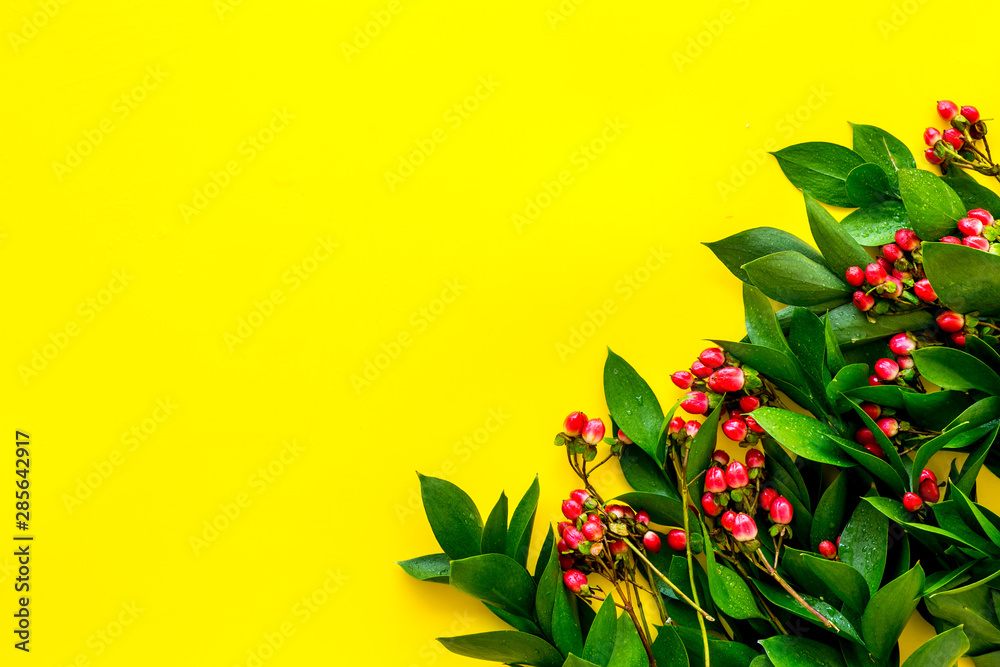 green herbs and red berries for summer design on yellow background top view mock up