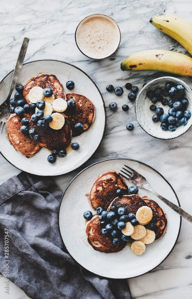 Healthy comfort breakfast set. Flat-lay of banana pancakes with blueberry and honey and cup of coffe