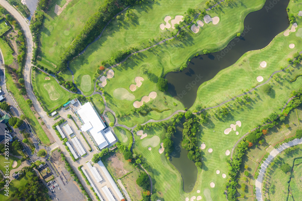 Aerial panoramic view of golf course and houses in city.