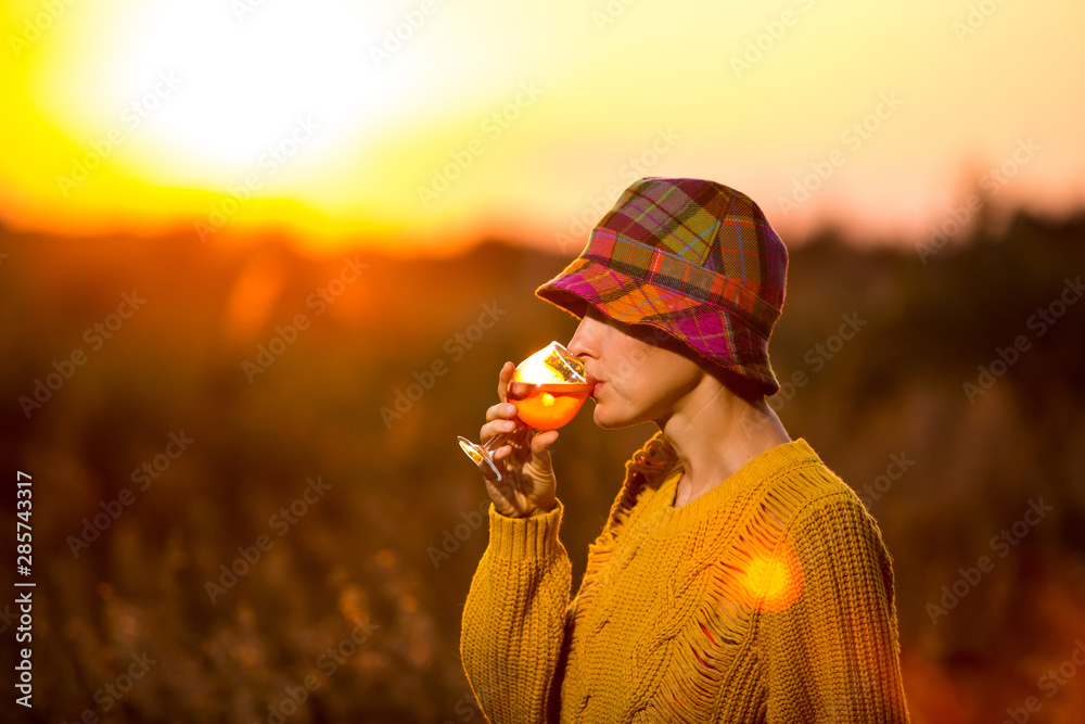 美丽的秋天女人喝着橙色的aperol（红酒）杯看日落-奢华的生活方式b