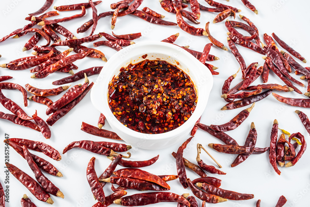 Ceramic stew with red pepper and dried chili on white background