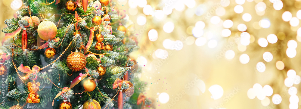 Christmas tree decorated with Golden balls and toy bears on a blurred, sparkling and fabulous fairy 