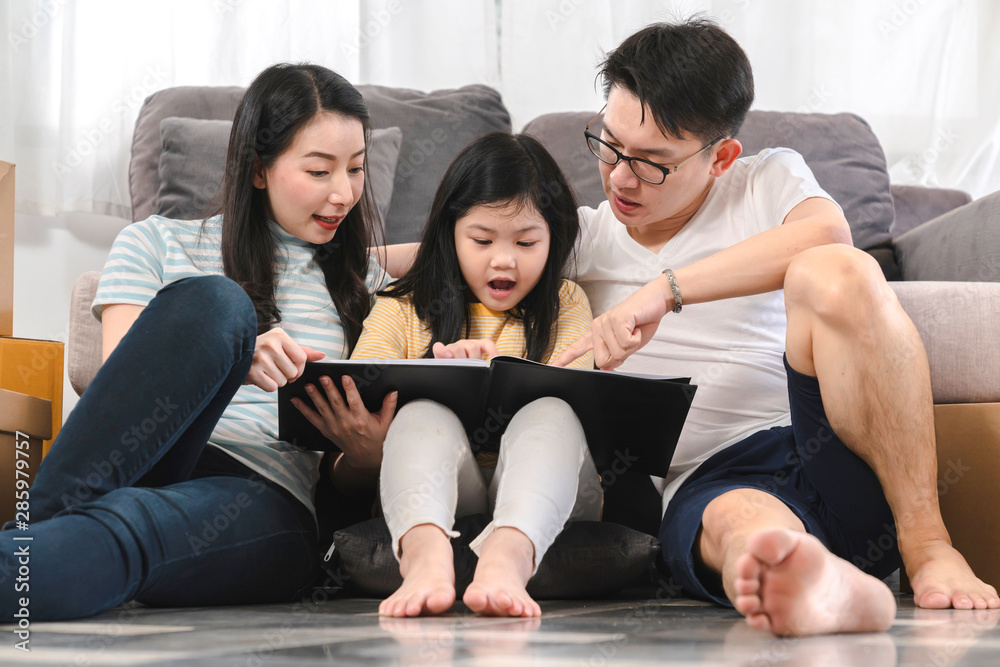 happiness asian family dad mom daughter sit relax enjoy watching tablet together with fun and exited