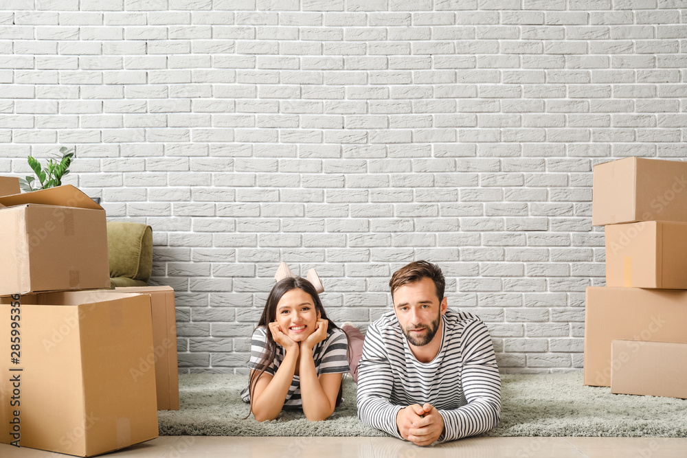 Young couple with belongings after moving into new house