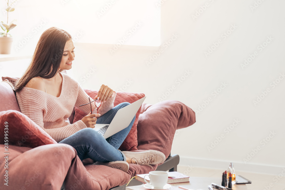 Young female blogger with laptop at home