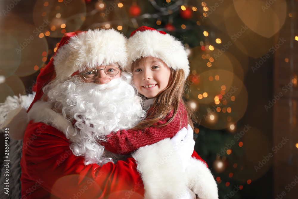 Santa Claus and little girl in room decorated for Christmas